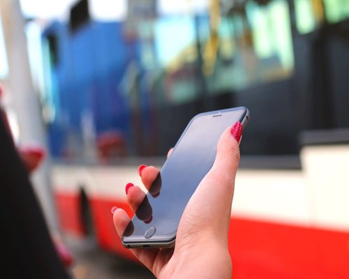 Someone holding a smartphone on a bus, showing the typical commuting environment