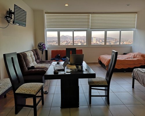 Person working comfortably on a laptop beside a bright window with natural light in a Mexican apartment